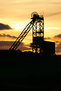 Sunset over the large wheel at Mynydd Parys Copper mines near Amlwch, ...