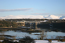 View of Menai Bridge, Menai Straits at low tide with snow covered Snow...