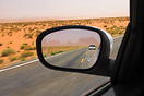 View through the wing mirror, driving through Monument Valley