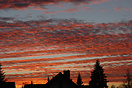 the sun is setting over a residential area of Munich