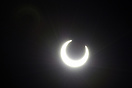 If you look closely you will see a solar flare behind the moon.