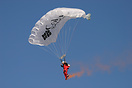 A paraglider descending into Chateau D'Oex during the balloon festival