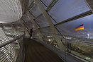 A young woman is looking towards the Flag in the Dome of the Reichstag...