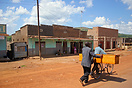 Two men transport a coffin on their bike