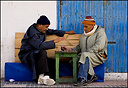 Two old men playing draughts in a Essaouira street
