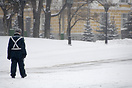 A soldier stands guard by the Kremlin in the snow.