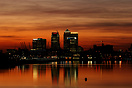 A view across the Thames towards London's Canary Wharf at sunset