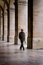 A man walking through the arches of the Praca do Comercio (Trade Squar...