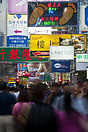 People walking under the advertisements on Mong Kok street in the Yau ...